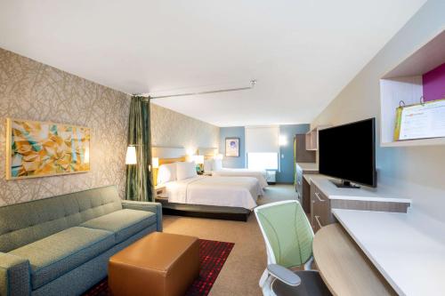 um quarto de hotel com um sofá e uma cama em Home2 Suites by Hilton Houston Bush Intercontinental Airport Iah Beltway 8 em Houston