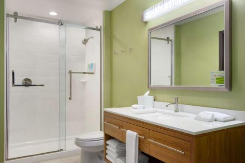 a bathroom with a sink and a shower with a mirror at Home2 Suites by Hilton Houston Stafford - Sugar Land in Stafford