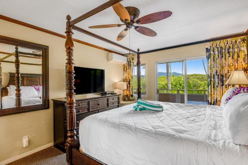 a bedroom with a bed and a ceiling fan at Plantation Hale J11 in Kapaa