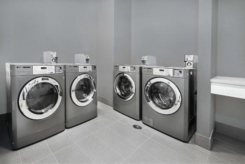 three washing machines are lined up in a laundry room at Homewood Suites By Hilton Houston Memorial in Houston