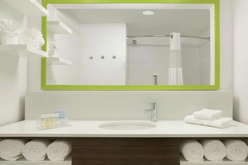 a bathroom with a sink with a mirror and towels at Hampton Inn - Houston/Brookhollow in Houston
