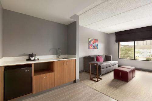 a kitchen with a sink and a living room with a couch at Hampton Inn - Houston/Brookhollow in Houston