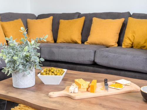 a coffee table with a tray of cheese and a couch at Mountain View Beautiful Large House By Cockermouth in Cockermouth