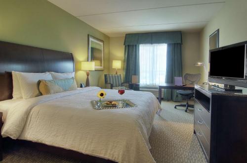 um quarto de hotel com uma cama com uma bandeja com flores em Hilton Garden Inn Houston-Pearland em Pearland