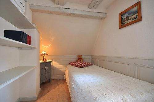 a small bedroom with a bed and a desk at Gite Chez Marcel in Riquewihr