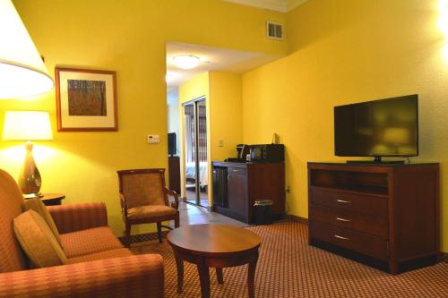 a hotel room with a living room with a tv and a couch at Hilton Garden Inn Houston West Katy in Katy