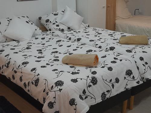 a bed with a black and white blanket and pillows at Studio Apartman Mary in Osijek