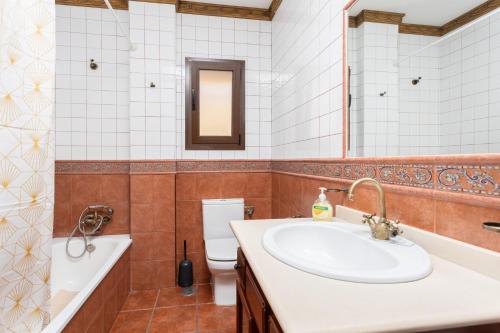 y baño con lavabo, bañera y aseo. en Villa Las Palomas 2 en Frigiliana