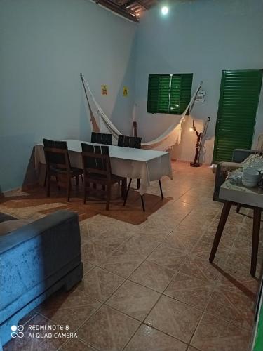 sala de estar con piano, sillas y sofá en Hostel do Cerrado, en Cavalcante