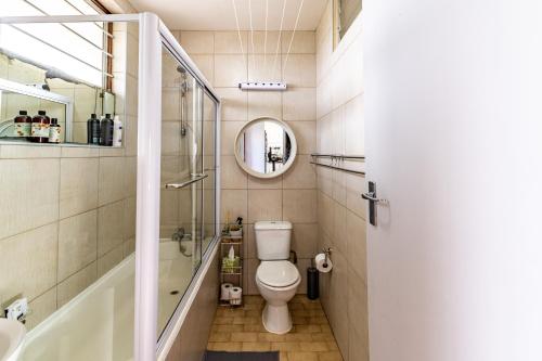 a bathroom with a toilet and a tub and a sink at Cosy Sky View Apartment in Ballito