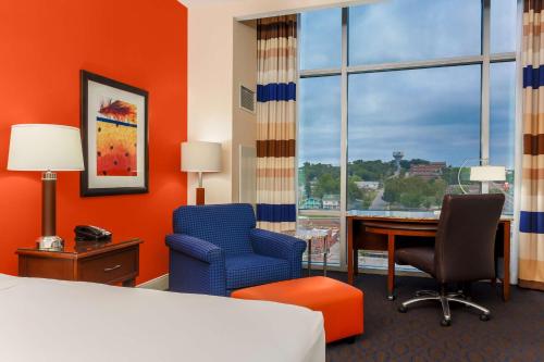 a hotel room with a bed and a desk and chairs at Hilton Branson Convention Center in Branson