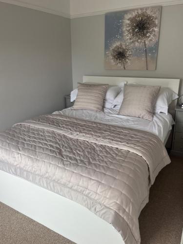 een groot bed in een witte kamer met een bed sidx sidx sidx bij Beachglass in Lynton