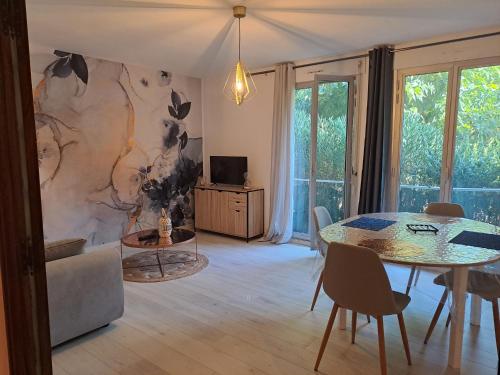 un salon avec une table et une télévision dans l'établissement T2 à 2min du centre +parking, à LʼIsle-sur-la-Sorgue