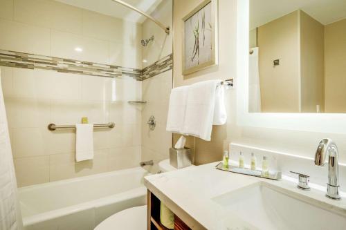 a bathroom with a sink and a tub and a toilet at DoubleTree by Hilton Huntington, WV in Huntington