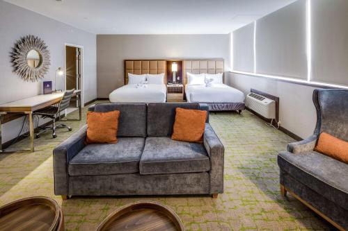 a hotel room with a couch and two beds at DoubleTree by Hilton Huntington, WV in Huntington