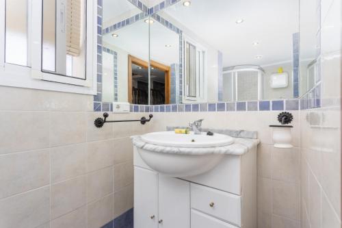 La salle de bains blanche est pourvue d'un lavabo et d'un miroir. dans l'établissement Villa Paloma, à Frigiliana