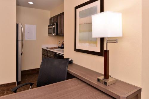 a kitchen with a table and a lamp on a desk at Homewood Suites by Hilton Houma in Houma