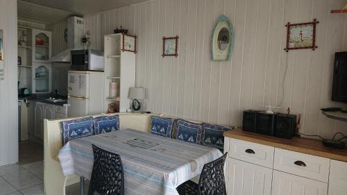 a kitchen with a table and chairs and a kitchen with at les pieds dans l'eau in Les Boucholeurs