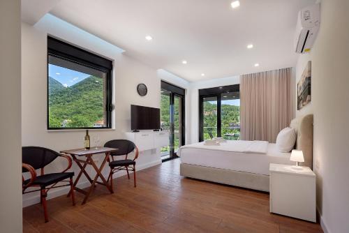 - une chambre avec un lit, une table et des chaises dans l'établissement Georgiy Lux Apartments, à Lastva