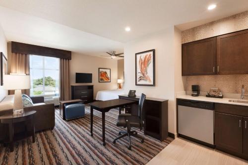 a hotel suite with a desk and a kitchen and a bed at Homewood Suites by Hilton North Houston/Spring in Spring