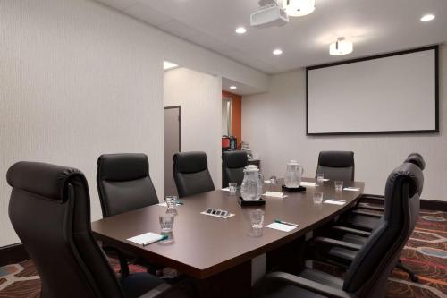 a conference room with a table and chairs and a screen at Homewood Suites by Hilton North Houston/Spring in Spring