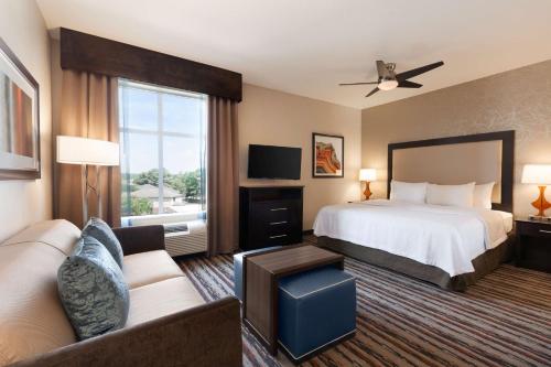 une chambre d'hôtel avec un lit et un canapé dans l'établissement Homewood Suites by Hilton North Houston/Spring, à Spring