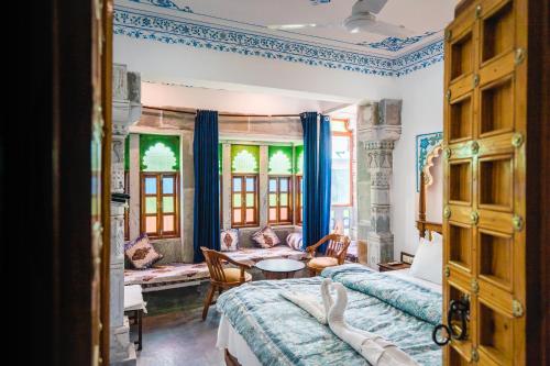 a bedroom with a bed and a table and chairs at Lassi Guest House in Udaipur