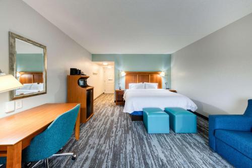 a hotel room with a bed and a blue couch at Hampton Inn Wilmington University Area in Wilmington