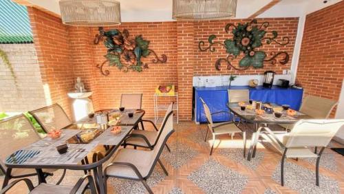 a patio with tables and chairs and a brick wall at HOTEL OBREGON in Iguala de la Independencia