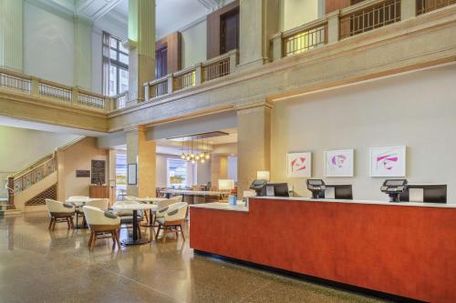 a lobby with a waiting area with chairs and a counter at Hilton Garden Inn Indianapolis Downtown in Indianapolis