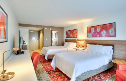 um quarto de hotel com duas camas e uma televisão em Hilton Garden Inn Indianapolis Northeast/Fishers em Fishers