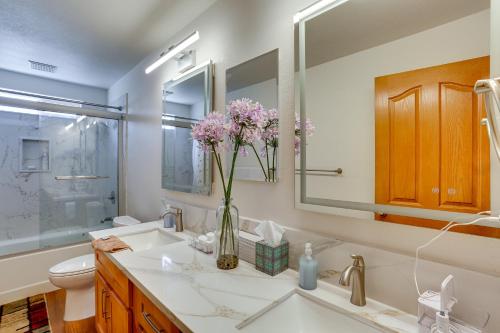 a bathroom with a sink and a vase of flowers at Seaside Eureka Vacation Rental with Bay Views! in Eureka