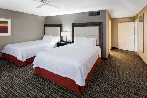 two beds in a hotel room with white sheets at Homewood Suites by Hilton Indianapolis At The Crossing in Indianapolis
