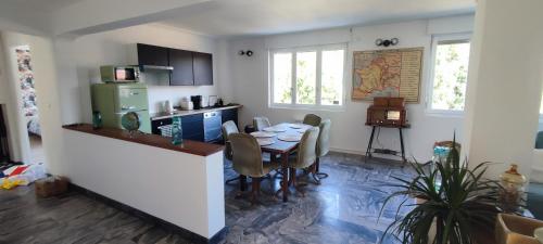 a kitchen with a table with chairs and a refrigerator at Bel appartement lumineux 3 chambres in Lay-Saint-Christophe