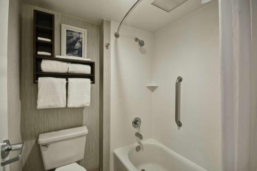 a bathroom with a tub and a toilet and a sink at Homewood Suites by Hilton Indianapolis Carmel in Carmel
