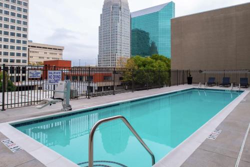 a swimming pool with a city skyline in the background at Hampton Inn & Suites Winston-Salem Downtown in Winston-Salem