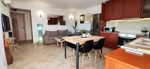 a kitchen and living room with a table and a couch at Ellora Suite in Salamís