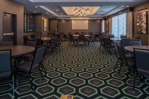 a conference room with tables and chairs and a projection screen at Hampton Inn & Suites Winston-Salem Downtown in Winston-Salem