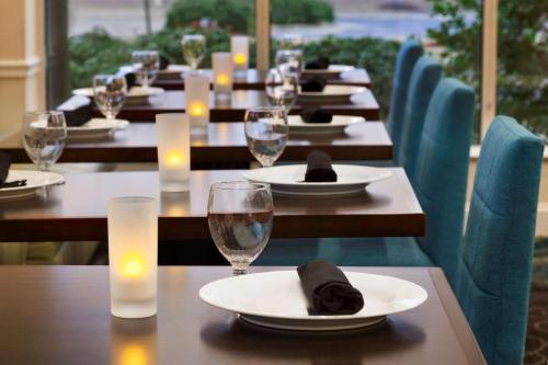 uma fila de mesas com copos e guardanapos em Hilton Garden Inn Winston-Salem/Hanes Mall em Winston-Salem