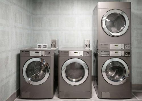 three washing machines and a washer and dryer in a room at Hilton Garden Inn Iowa City Downtown University in Iowa City