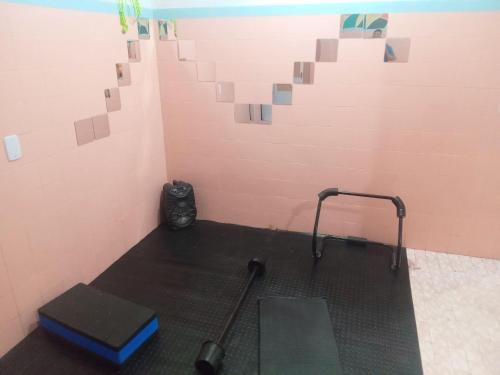 a room with a treadmill and a pink wall at Hostel Leonardo in Vitória