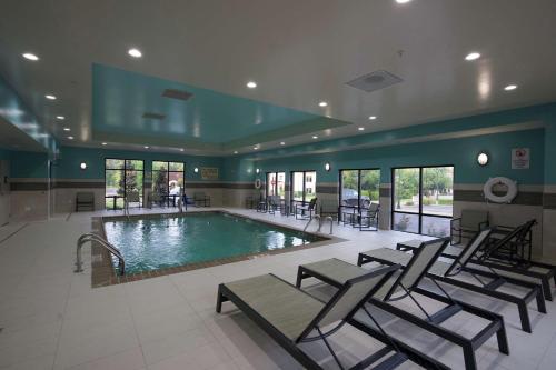里奇蘭的住宿－Hampton Inn & Suites Ridgeland，一座游泳池,四周摆放着椅子