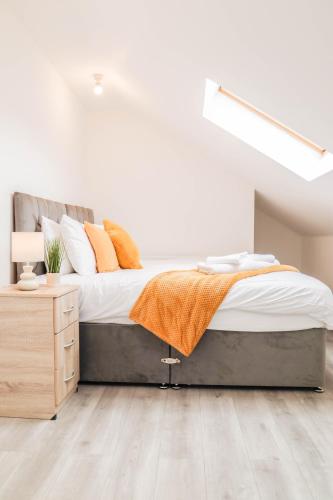 a bedroom with a bed and a wooden floor at Modern House with Gated Driveway and Free WiFi in Luton