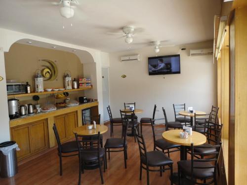 una sala da pranzo con tavoli, sedie e bancone di Hotel Zafra a Torreón