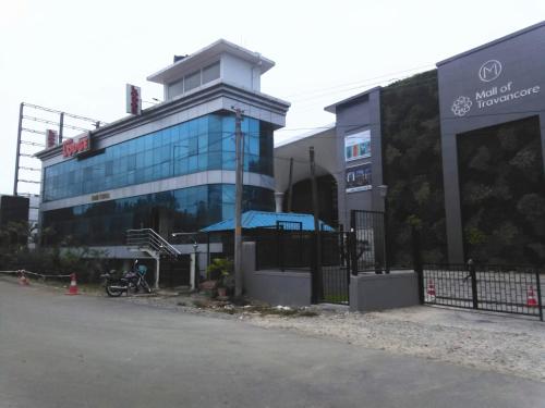 a large glass building with a bike parked in front of it at Rosh Tower in Trivandrum