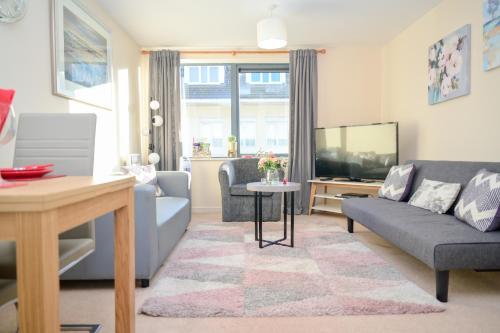 a living room with a couch and a tv at One Bedroom Apartment TCA-78 in Watford