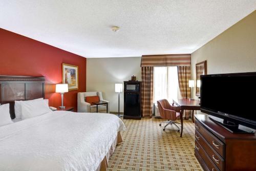 a hotel room with a bed and a flat screen tv at Hampton Inn Jacksonville - I-95 Central in Jacksonville