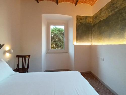 a bedroom with a white bed and a window at AFFITTACAMERE SobborgoSpina47 in Sarzana