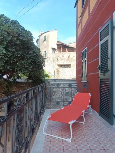 a red bench on the balcony of a building at AFFITTACAMERE SobborgoSpina47 in Sarzana