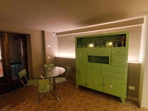 a green cabinet in a room with a table at AFFITTACAMERE SobborgoSpina47 in Sarzana